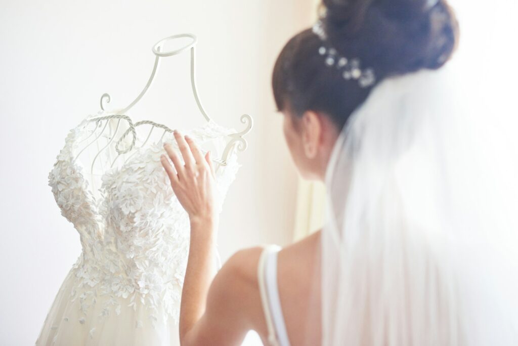 Elegant bride puts a wedding gown in her room
