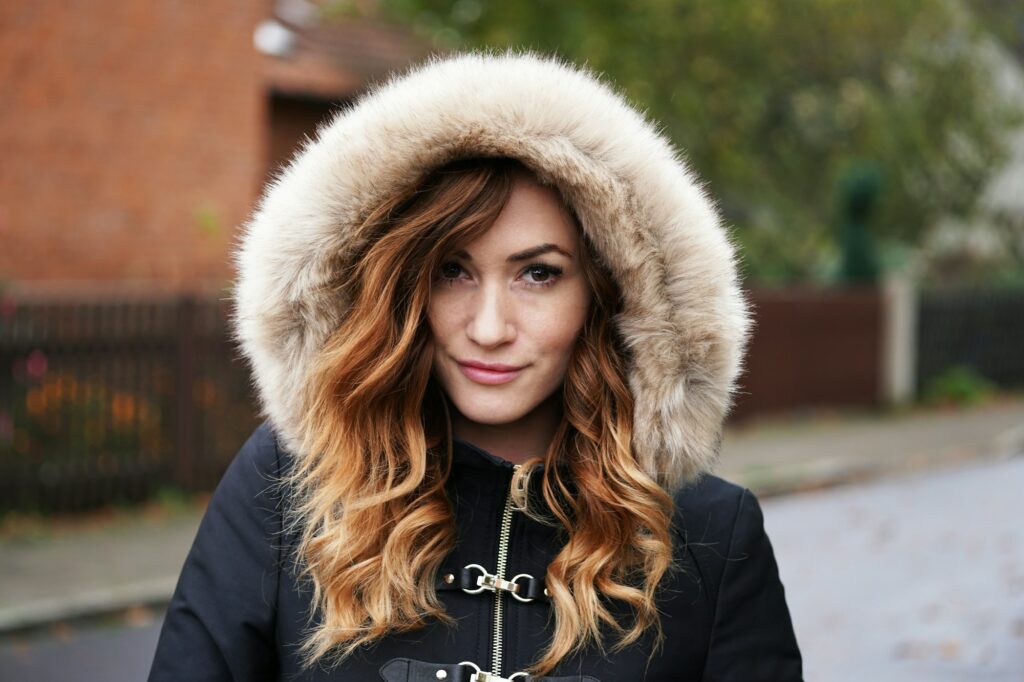 young woman wearing winter coat with fake fur hood outdoors